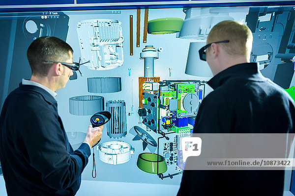 Engineers inspecting component parts in 3D virtual reality suite