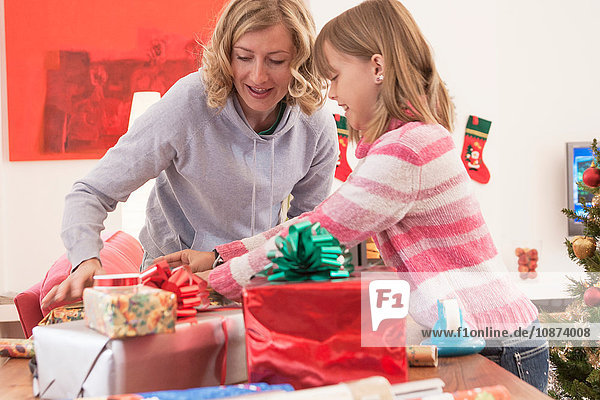 Mother and daughter wrapping christmas gifts