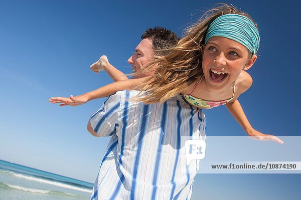 Mittelgroßer Mann mit Tochter über der Schulter am Strand  Mallorca  Spanien