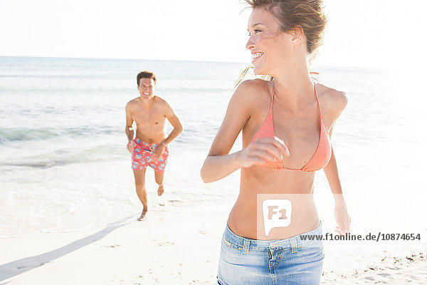 Man running and chasing girlfriend on beach  Majorca  Spain