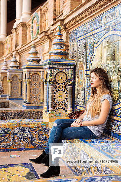 Junge Frau sitzt entspannt auf der Plaza de Espana  Sevilla  Andalusien  Spanien