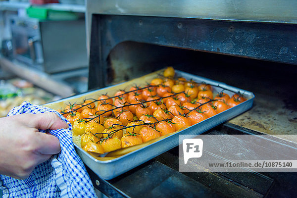 Chefkoch beim Kochen von Tomaten in der traditionellen italienischen Restaurantküche Nahaufnahme