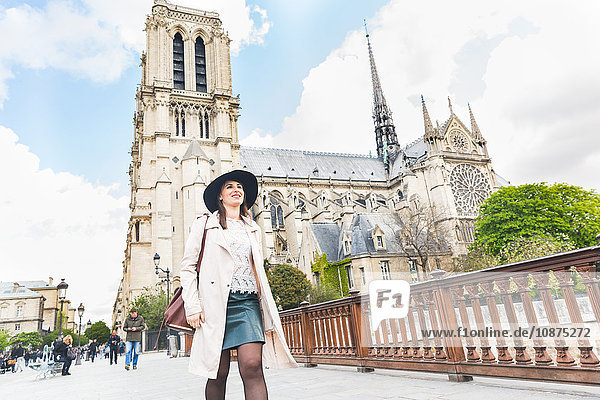 Stilvolle junge Frau beim Spaziergang in Notre Dame Paris Frankreich