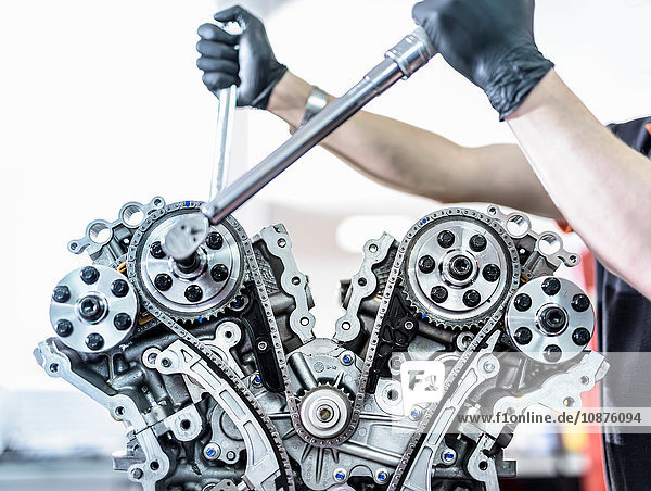 Ingenieur der in einer Rennwagenfabrik an einem Motor arbeitet Nahaufnahme