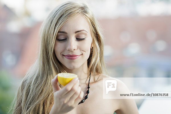 Langhaarige blonde junge Frau mit einer Zitrone