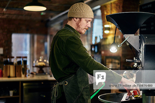 Männlicher Kaffeehausbesitzer mit Kaffeeröster