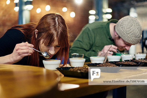 Coffee-Shop-Team riecht Schalen mit Kaffee und Kaffeebohnen bei der Verkostung