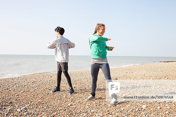 Mann und Frau trainieren  twisten am Strand von Brighton