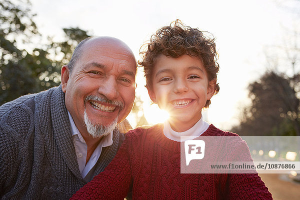 Portrait of grandfather and grandson looking at camera smiling