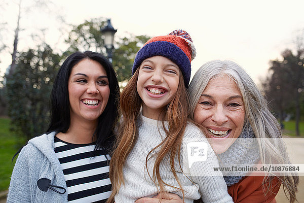 Portrait of mother and daughter and grandmother looking at camera smiling
