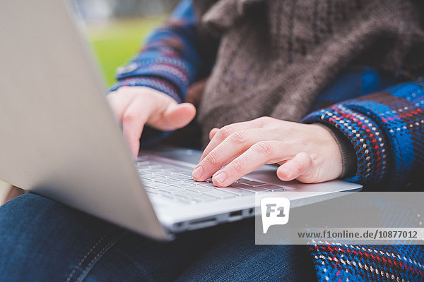 Young woman using laptop  outdoors  close-up