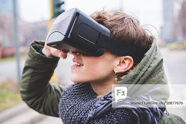Junge Frau im Freien  die ein Virtual-Reality-Headset trägt