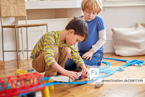 Two young boys playing with toy train set
