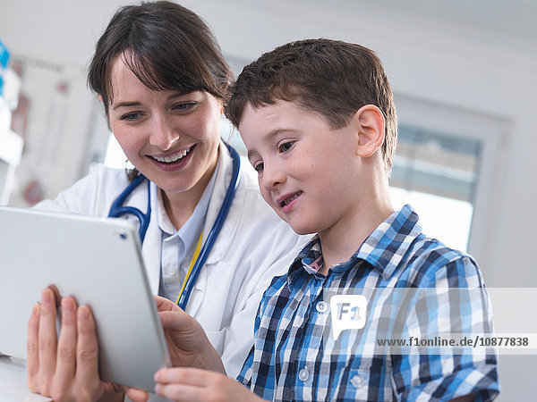 Arzt und Junge mit digitalem Tablett