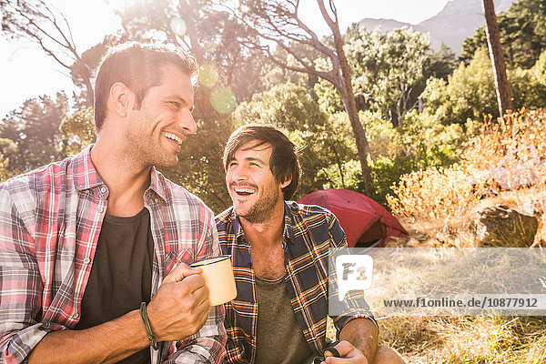 Two male campers chatting over coffee in forest Deer Park Cape Town South Africa