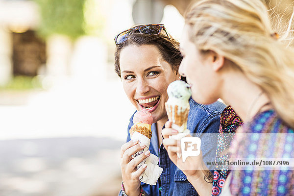 Friends holding ice cream cone smiling