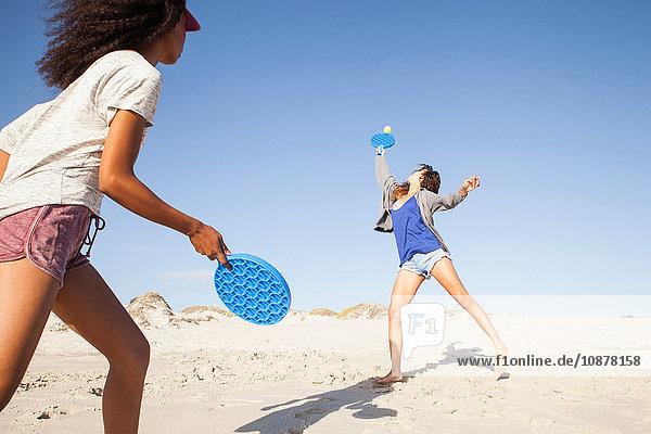 Women on beach playing tennis