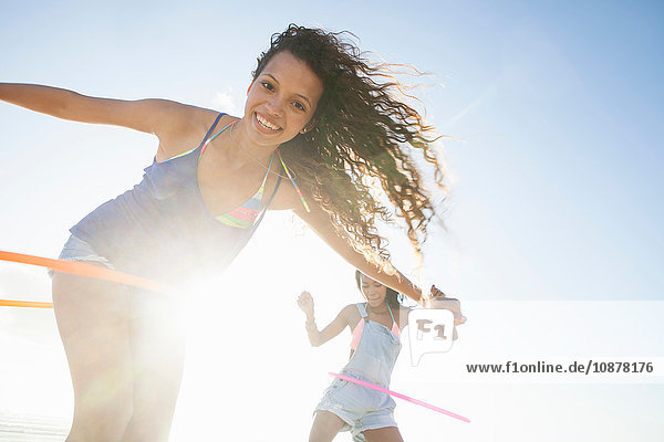 Frauen mit Hula-Hoop-Reifen die lächelnd in die Kamera schauen