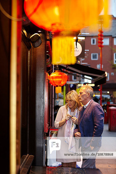 Ein reifes Paar liest die Speisekarte eines Restaurants in China Town in der Abenddämmerung  London  Großbritannien