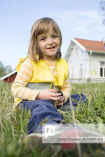 Schweden  Vastergotland  Olofstorp  Bergum  Portrait eines Mädchens (4-5) im Gras sitzend