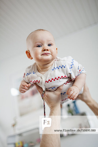 Schweden  Mann hält Baby-Sohn (2-5 Monate) in Händen