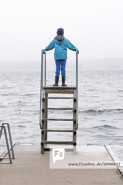 Schweden Bohuslan Halleback Rückansicht des Jungen (10-11) der auf einem Sprungturm am Pierrand steht Schweden, Bohuslan, Halleback, Rückansicht des Jungen (10-11), der auf einem Sprungturm am Pierrand steht