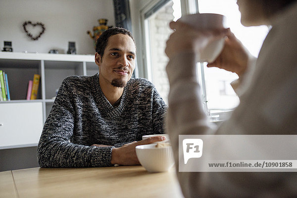 Schweden, Junges Paar am Tisch sitzend und Kaffee trinkend