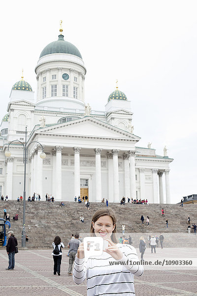 Finnland Uusimaa Helsinki Senaatintori Junge Frau fotografiert sich selbst mit lutherischer Kathedrale im Hintergrund.