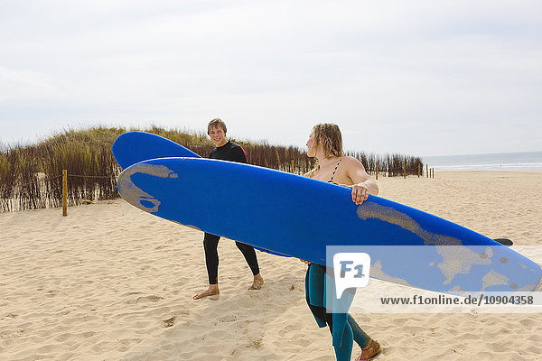 Portugal Lissabon Zwei Personen mit Surfbrettern am Strand