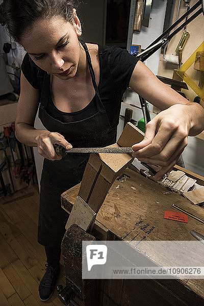 Luthier manufacturing a guitar in her workshop