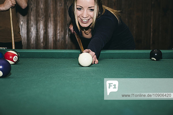 Woman playing pool billard in a bar  smiling