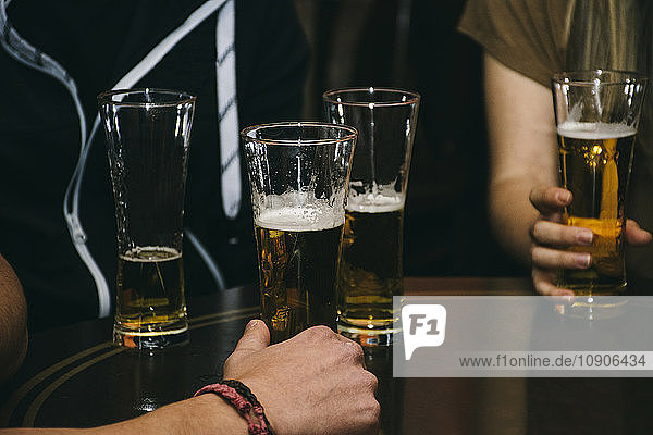 Group of people with glasses of beer on a table in a bar