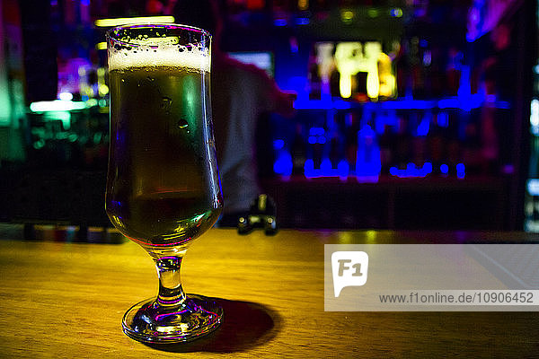 Glass of beer on counter of a bar
