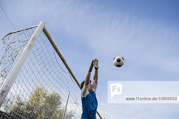 Football goalkeeper making a safe