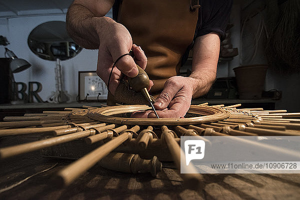 Craftsman manufacturing a mirror in his workshop