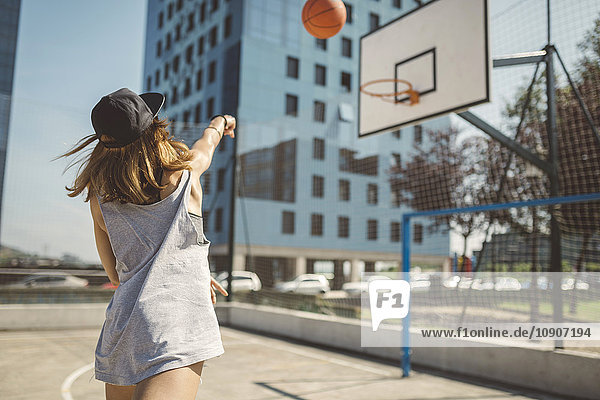 Junge Frau zielt auf Basketballkorb