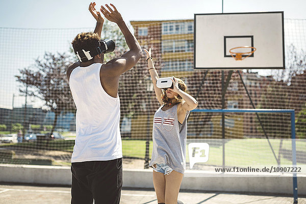 Junges Paar spielt Basketball mit Virtual-Reality-Brille auf