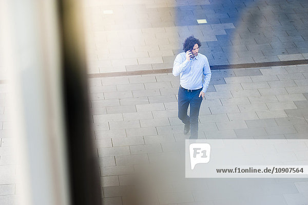 Mann auf der Straße telefoniert mit Smartphone