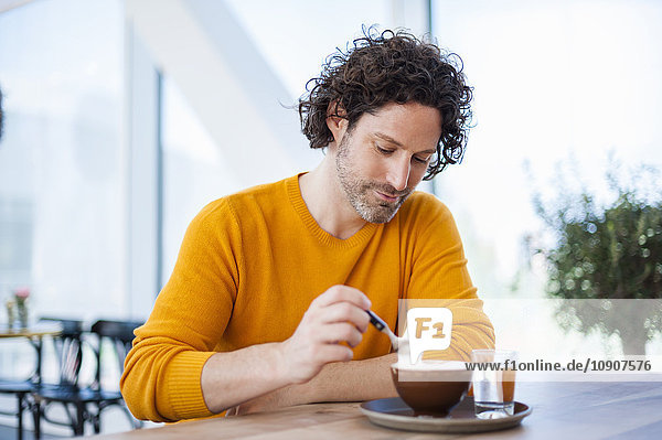 Porträt eines nachdenklichen Mannes mit Tasse Cappuccino