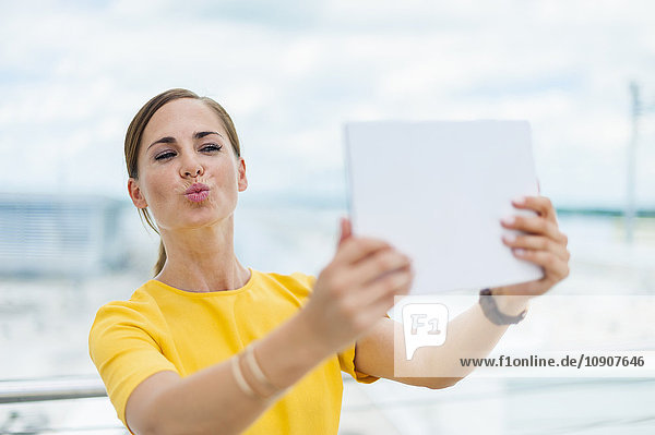 Brunette woman taking a selfie with digital tablet