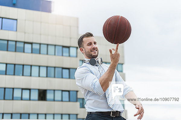 Businessman playing basketball outdoors