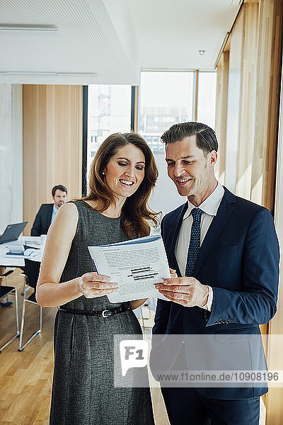 Businessman and woman discussing booklet in office