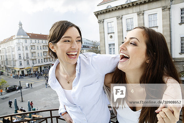 Zwei glückliche Frauen auf dem Balkon