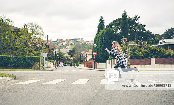 Junge Frau beim Skateboarden auf der Straße
