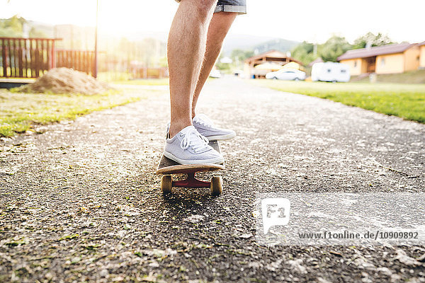 Beine eines Mannes auf dem Skateboard stehend