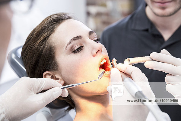 Junge Frau beim behandelnden Zahnarzt