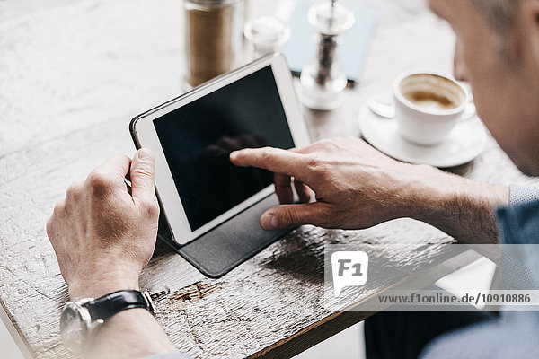 Mann im Café mit digitalem Tablett