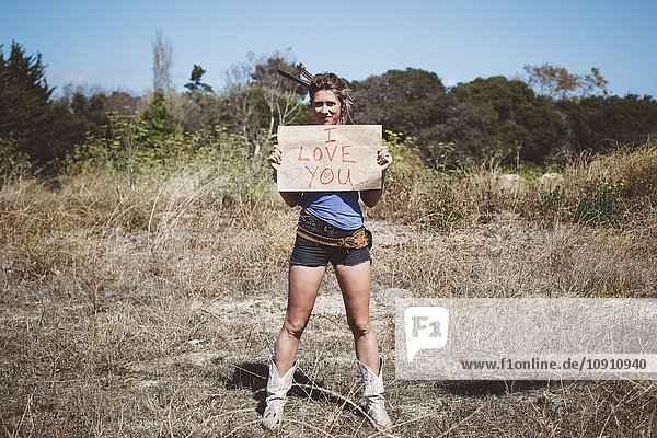 Hippie holding 'I love you' sign in the nature