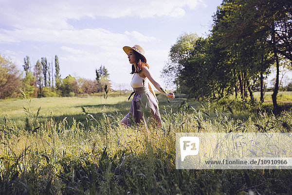 Young woman walking on a meadow in spring