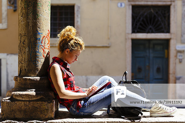 Italien  Verona  Frau im Freien sitzend mit digitalem Tablett